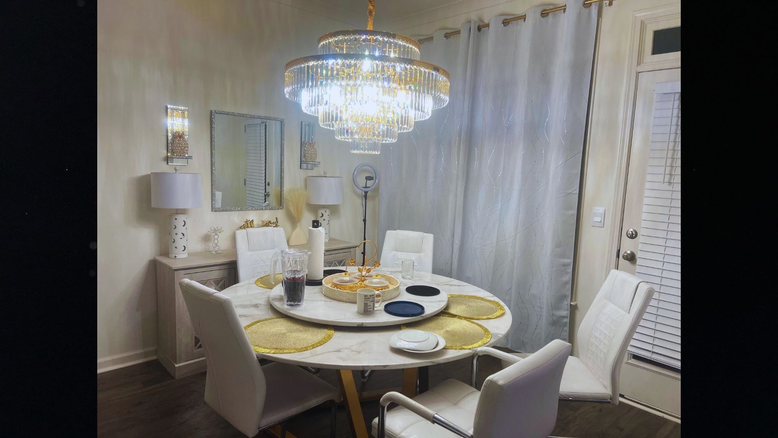 chandelier lights hanging at ceiling where 4 chairs and dining table in a room