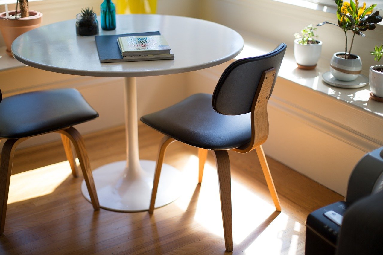 Round coffee table with books and flower vessel, 2 chairs