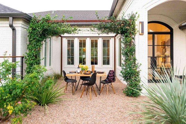 few chairs and a table in the surrounding of a garden