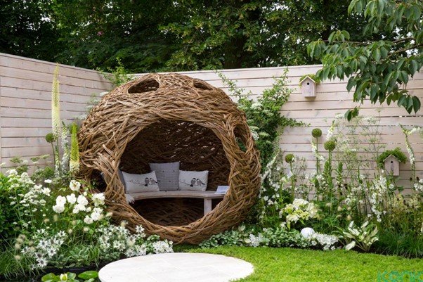 a nest is placed in garden so that two people can seat in the nest