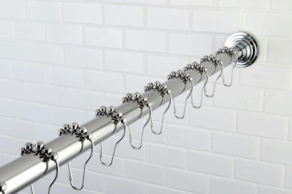 a steel silver color shower curatin rod perfectly adjusted in a bathroom side wall with hanging clips for curtain