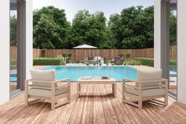 poolside seating area with two chairs, tables on the ground.