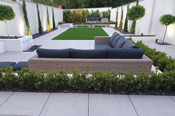 sofa set and lot of trees surrounding the garden