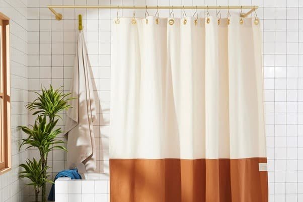 a bathroom curtain is hanging in with curtain rods, alsotree, towel, bathtub in the bathroom.