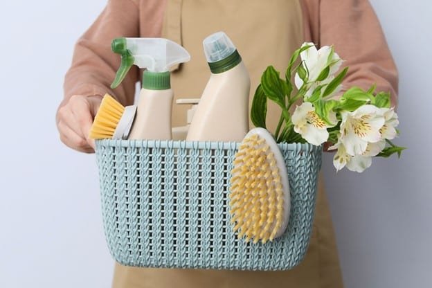 one person is holding basket in her hand where she carries home cleaning accessories.