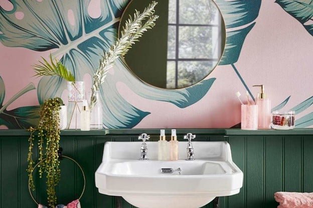 a sink, circular mirror, hand soap, trees in a bathroom