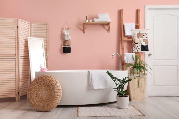 a bathtub, basket, fence, trees in a bathroom